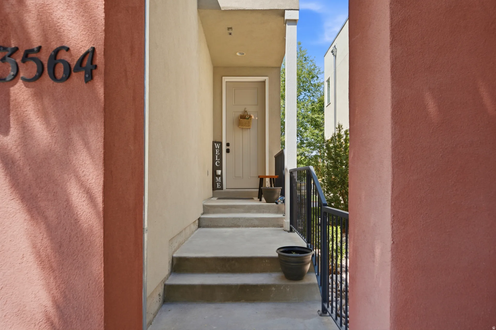 Entryway featuring a light-colored door with dark hardware, recessed lighting, and a stucco exterior