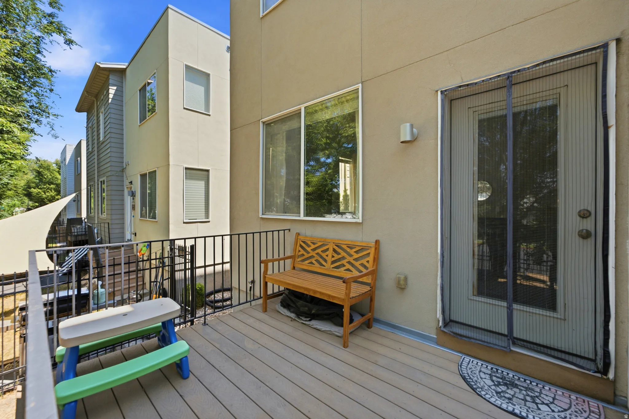 Private outdoor deck featuring composite decking and black metal railings