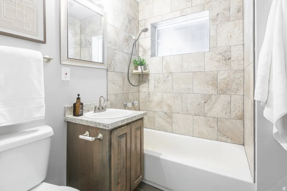 Spa-inspired bathroom featuring a wood-finish vanity with integrated storage, white ceramic vessel sink, and polished chrome faucet