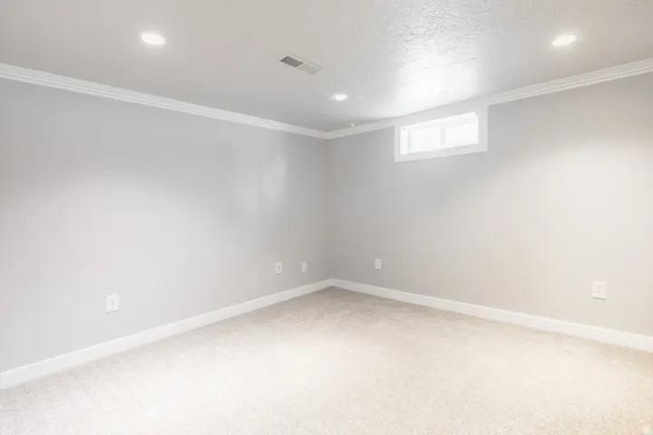 Spacious secondary bedroom featuring neutral paint finishes, recessed ceiling lighting, and carpet flooring throughout