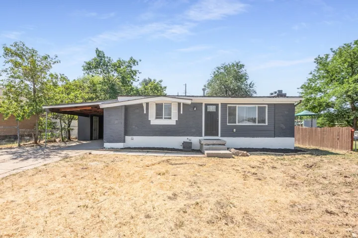 Ranch-style residence featuring a dark gray exterior with white trim and a contrasting white foundation