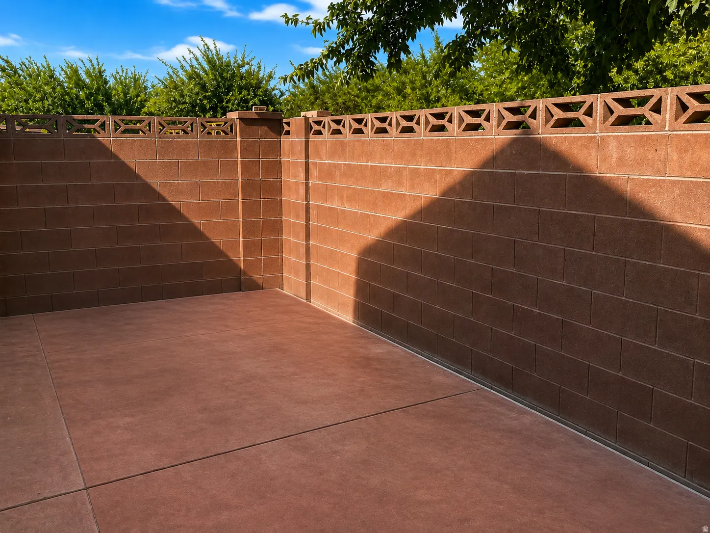 Private courtyard with substantial brick perimeter walls and decorative lattice-top fencing