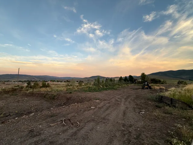 Expansive vacant land with open acreage, natural terrain, and distant mountain backdrop
