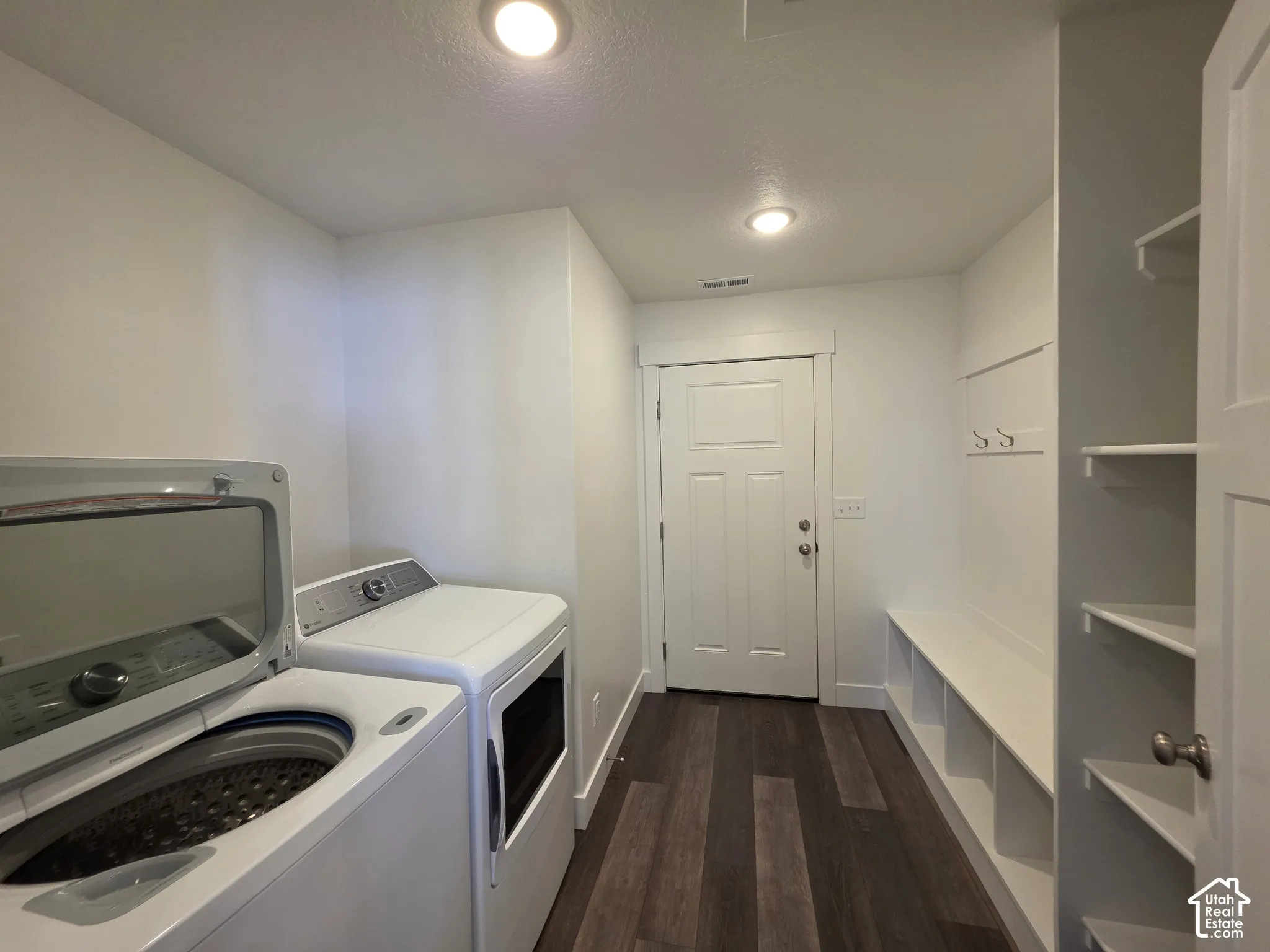 Dedicated laundry area featuring wood-finish flooring, recessed lighting, and a built-in bench with storage cubbies
