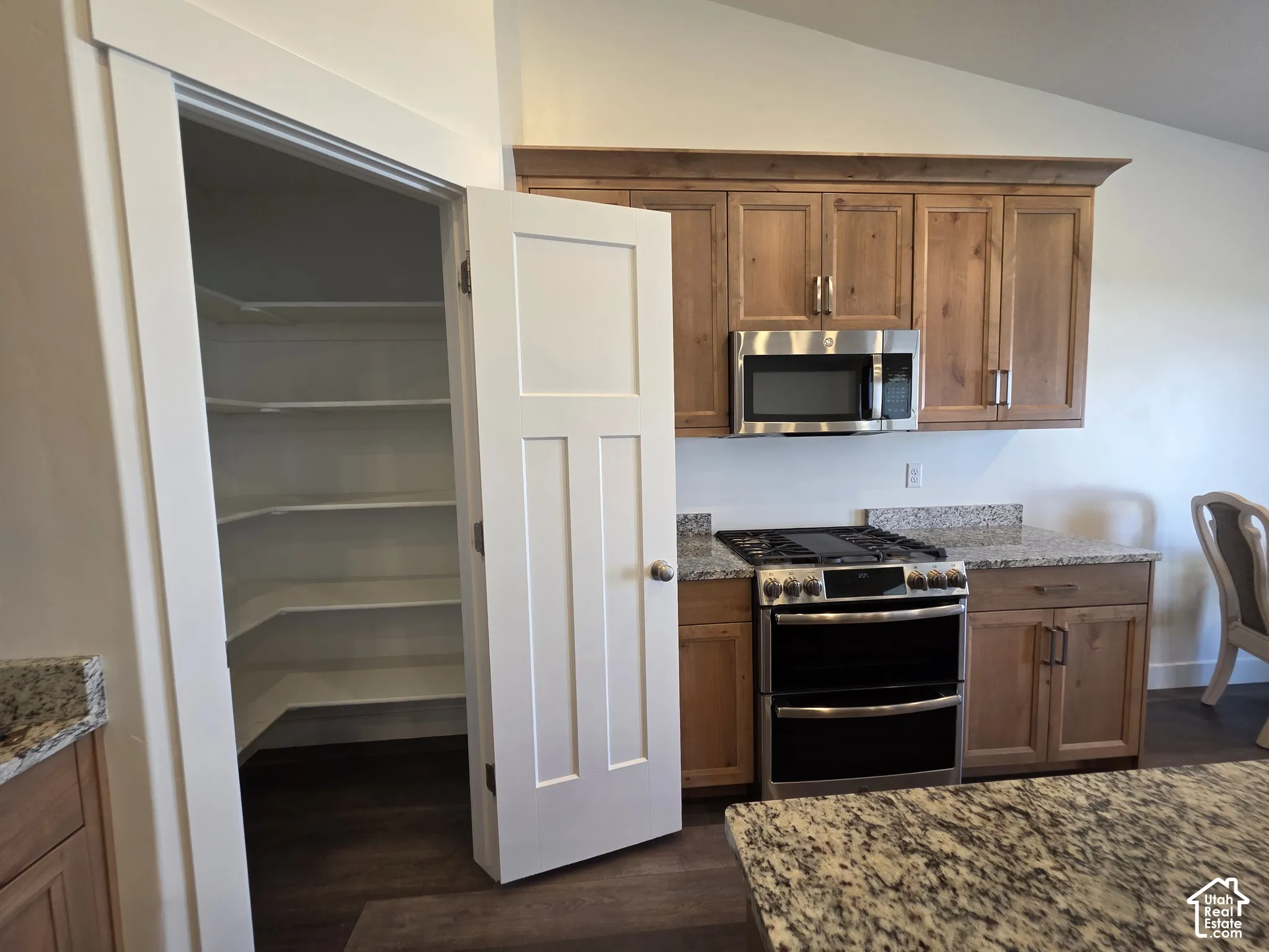 Kitchen pantry featuring multiple shelves and a three-panel interior door