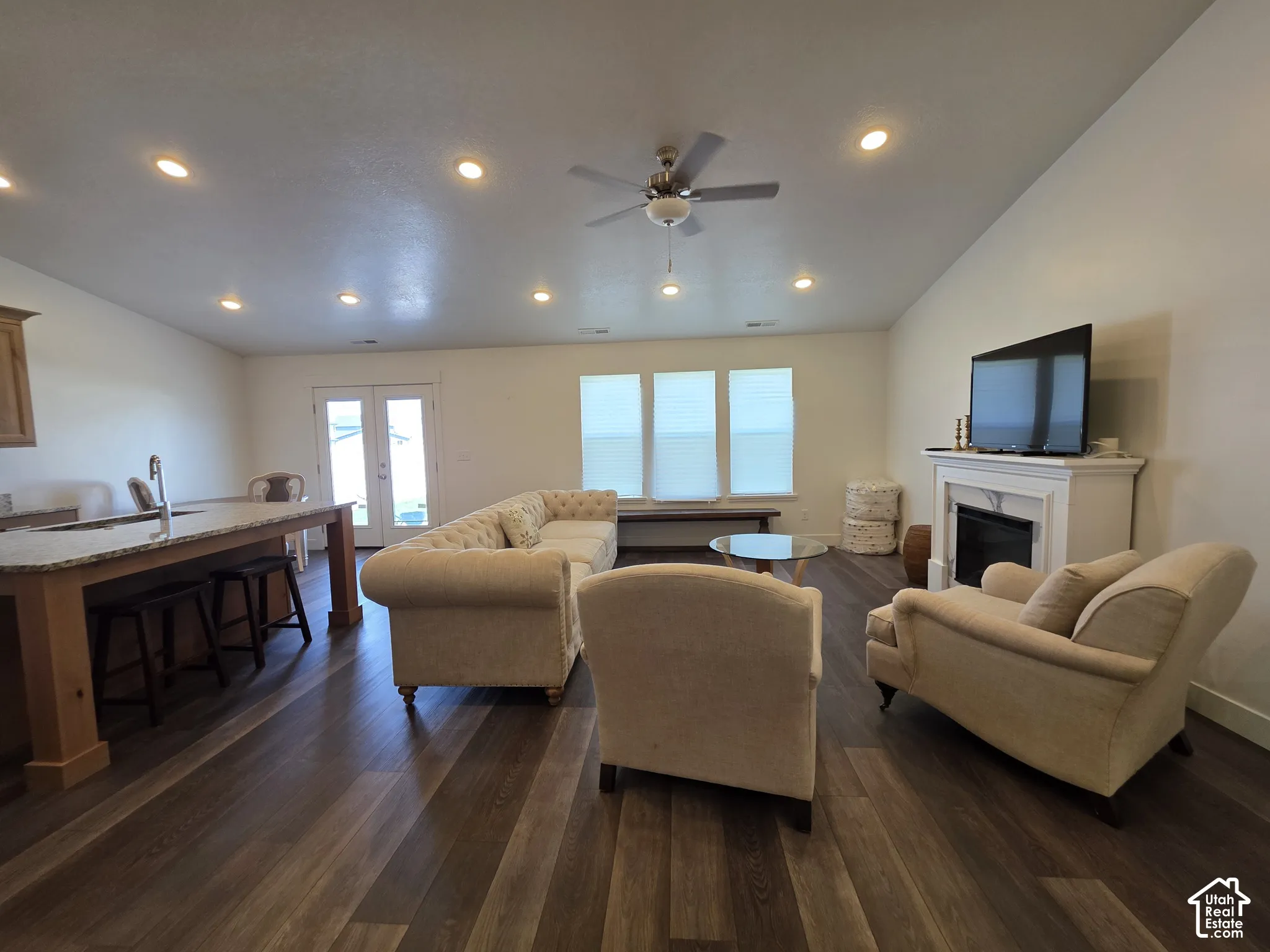 Open-concept living area with wood-finish flooring, recessed lighting, and a ceiling fan
