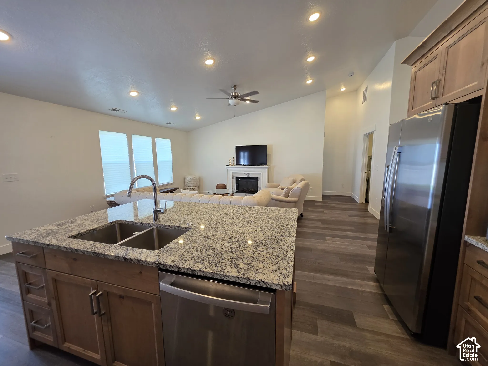 Kitchen island featuring a double basin stainless steel sink, granite countertop, and integrated dishwasher