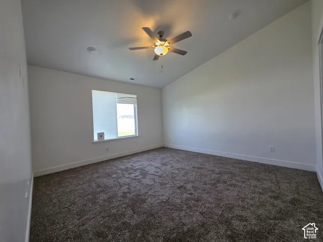 Spacious bedroom with neutral wall finishes, carpeted flooring, and abundant natural light from a large window