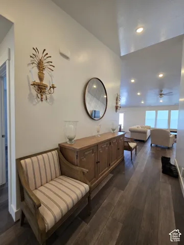 Spacious hallway featuring wood-finish flooring, recessed lighting, and a vaulted ceiling