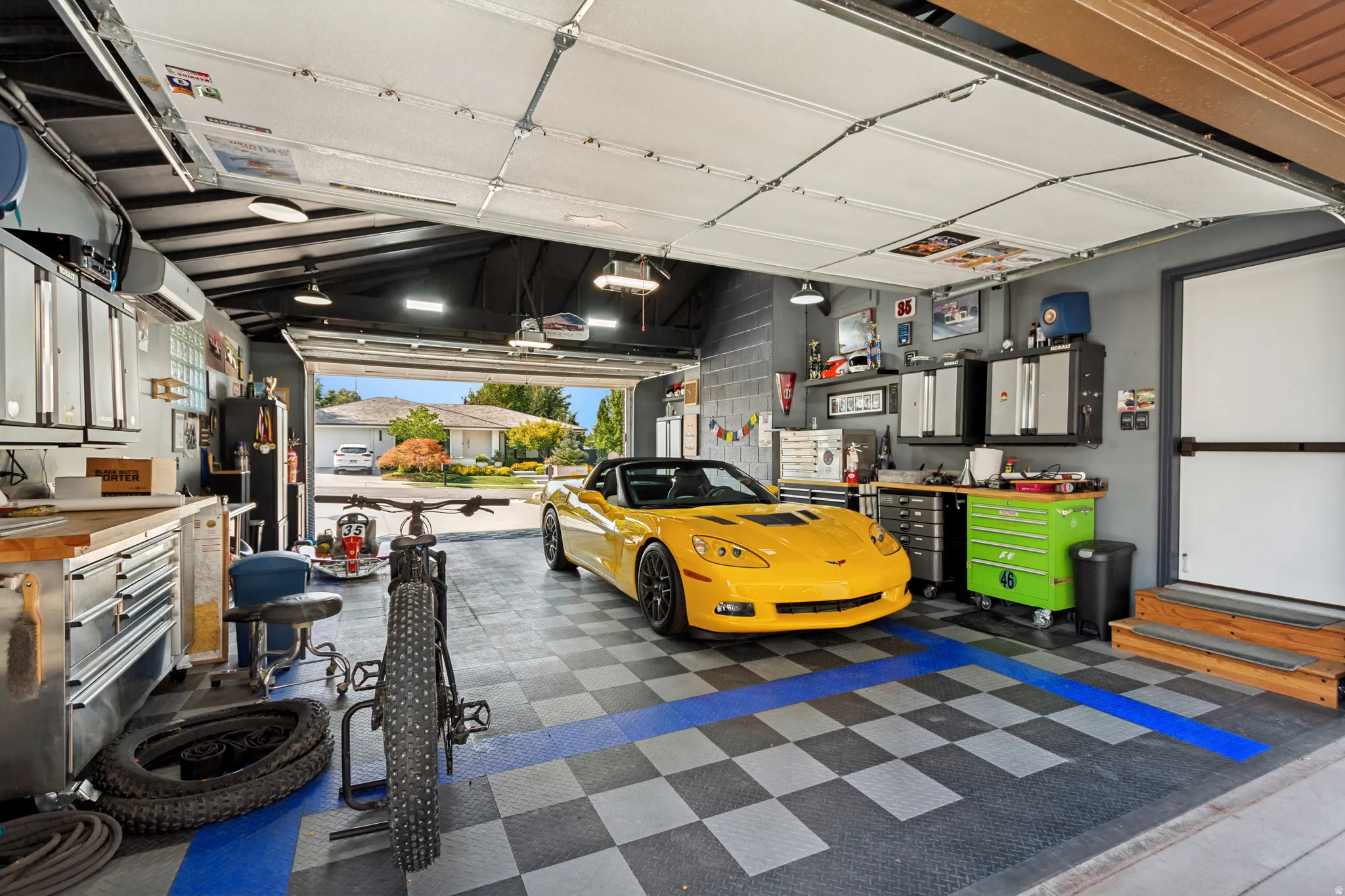 Attached Garage, Approximately 695 sq ft. Double garage doors for front and back access. A/C and Heat, durable black, gray, and blue checkered flooring,