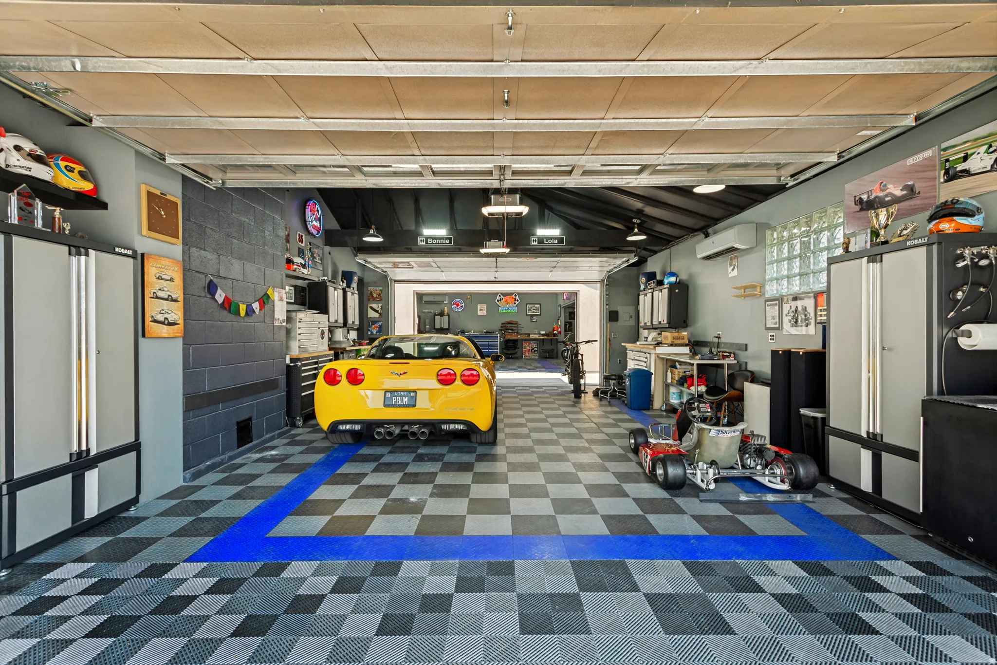 Attached Garage, Approximately 695 sq ft. Double garage doors for front and back access. A/C and Heat, durable black, gray, and blue checkered flooring,