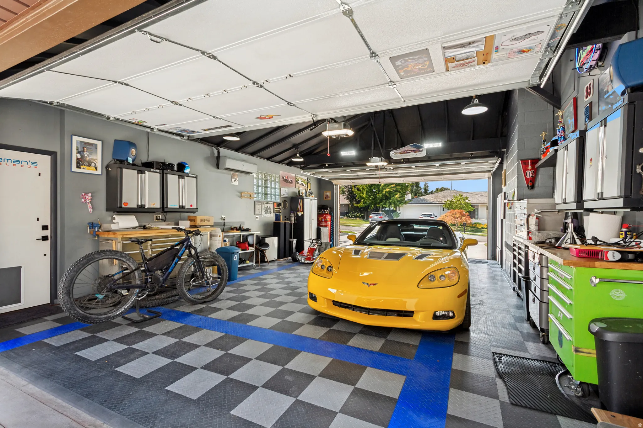 Attached Garage, Approximately 695 sq ft. Double garage doors for front and back access. A/C and Heat, durable black, gray, and blue checkered flooring,