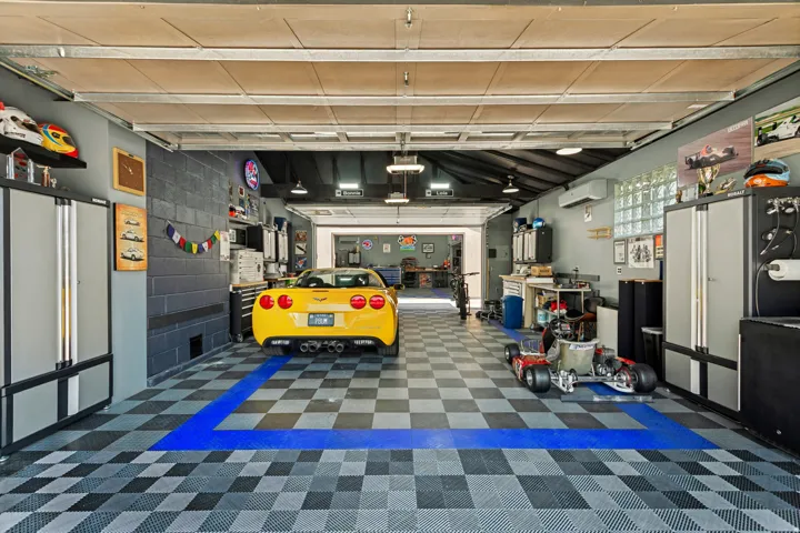Attached Garage, Approximately 695 sq ft. Double garage doors for front and back access. A/C and Heat, durable black, gray, and blue checkered flooring,