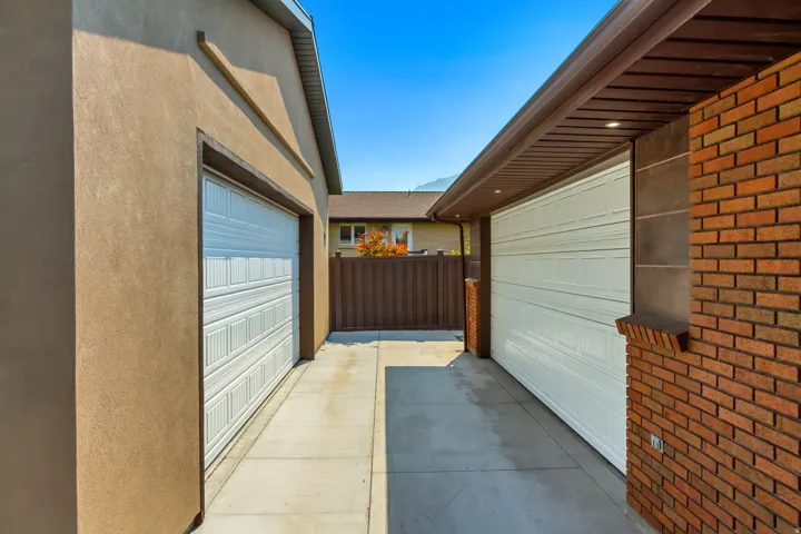 The attached front garage and rear workshop are connected by an open breezeway, allowing the space to function as one expansive workshop or two separate work areas.
