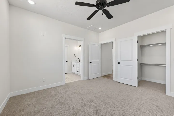 Spacious room featuring neutral carpet flooring, recessed lighting, and a ceiling fan