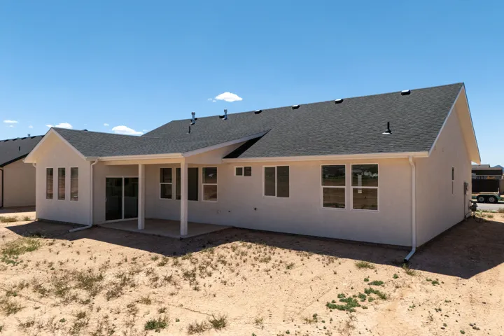 Modern single-story residence featuring a clean stucco exterior with a gabled roofline and architectural detail