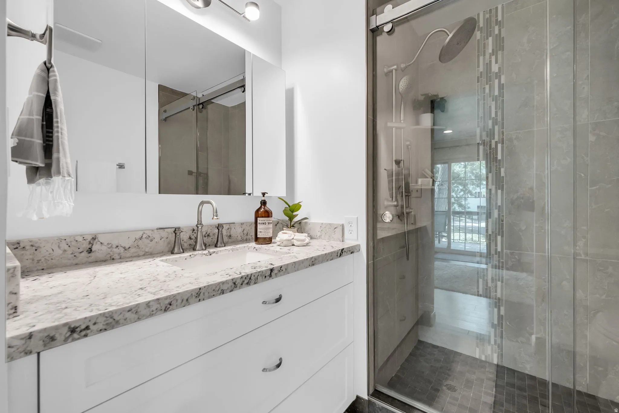 Spa-inspired primary bathroom featuring a floating white vanity with an expansive marble-look countertop, dual sink setup, and polished nickel fixtures