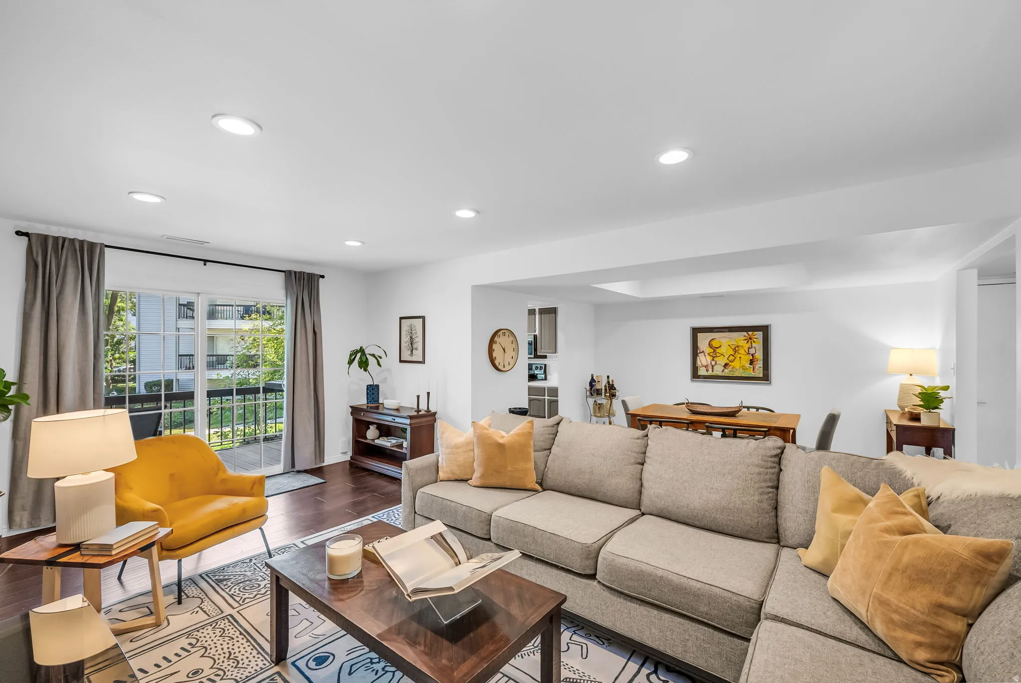 Sophisticated living room featuring a neutral upholstered sectional sofa, recessed ceiling lighting, and large sliding glass doors that frame natural light and outdoor access