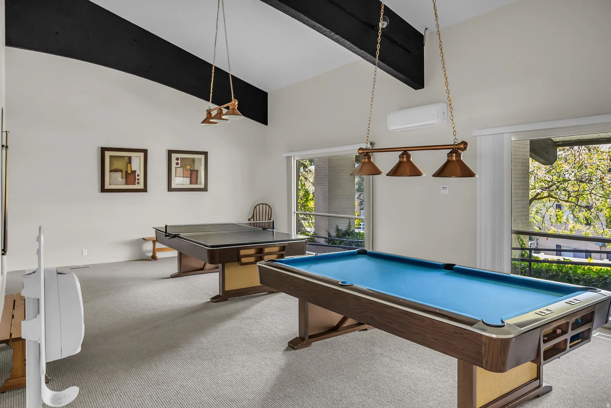 Recreational room featuring a billiard table, a second game table, high vaulted ceilings with exposed beams, and large windows