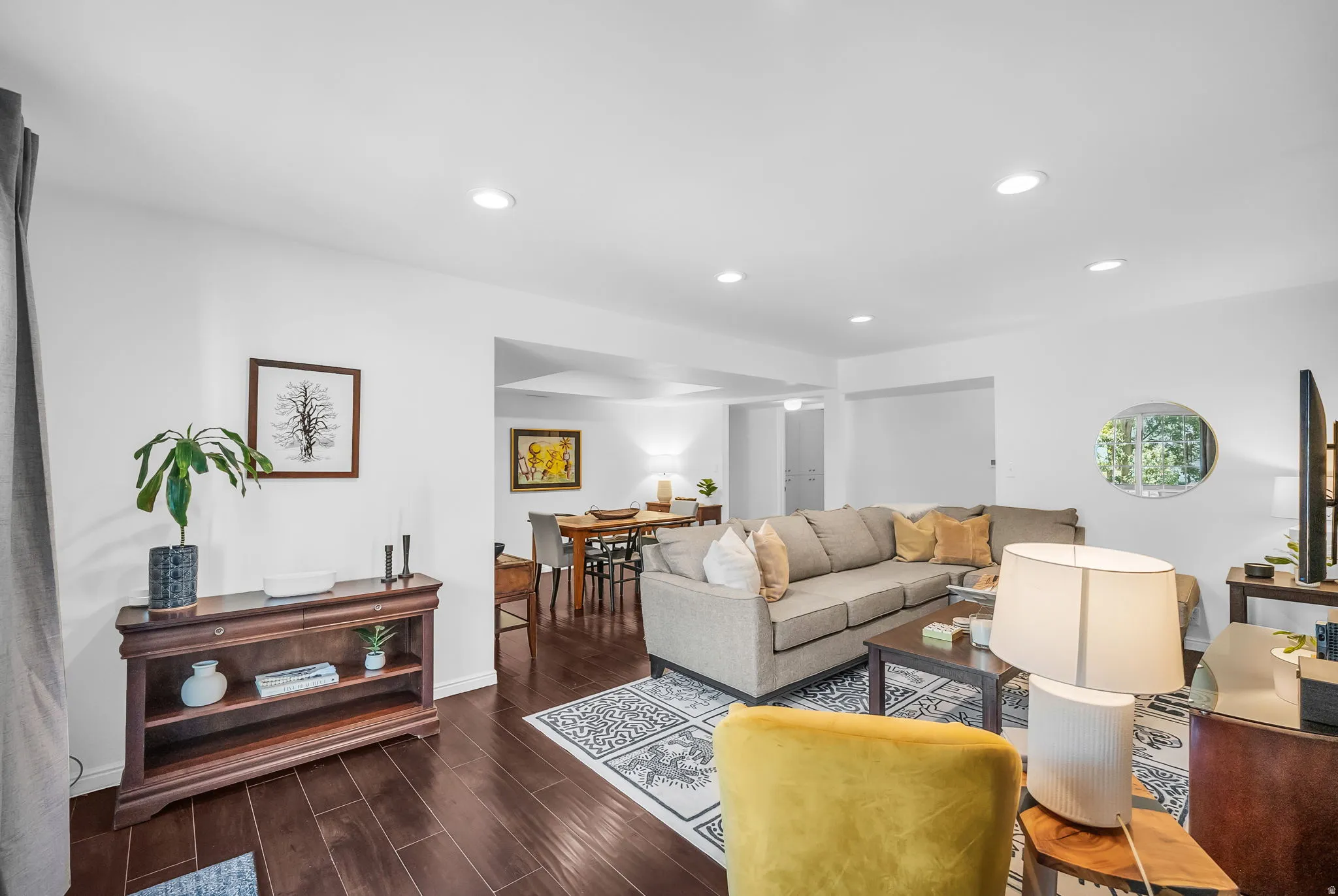 Bright and spacious living area showcasing hardwood flooring, recessed ceiling lighting, and a neutral color palette