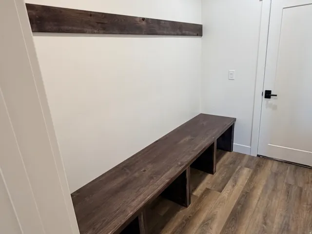 Built-in wood-finish bench with coordinating wall-mounted accent trim