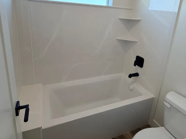 Bathtub with white surround and integrated corner shelving