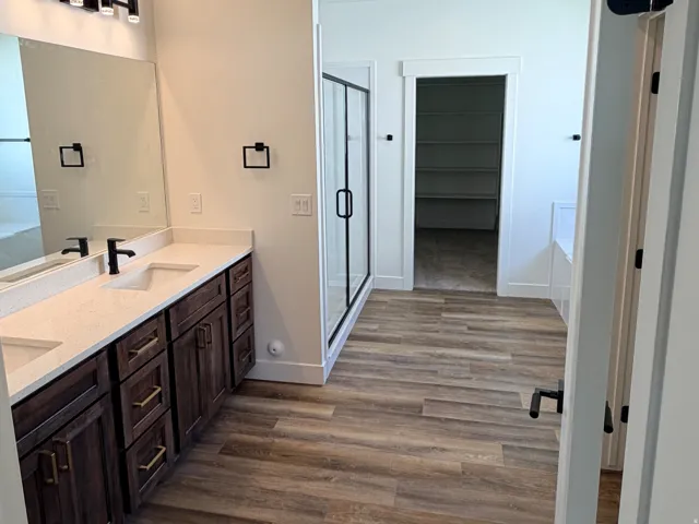 Dual vanity with dark wood-finish cabinetry, white countertops, and undermount sinks