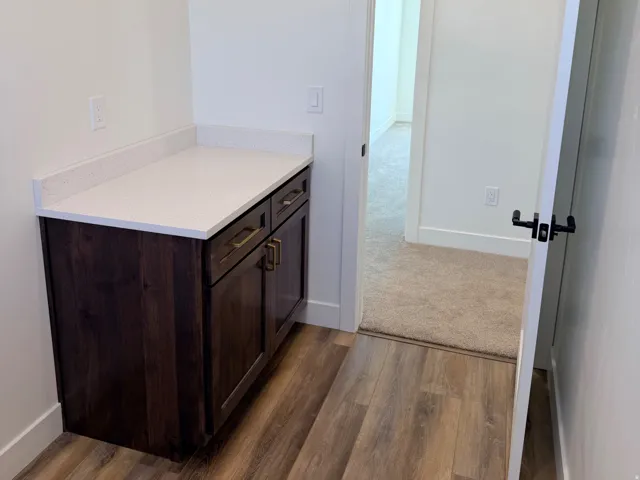 Built-in cabinetry with a white countertop and brass hardware