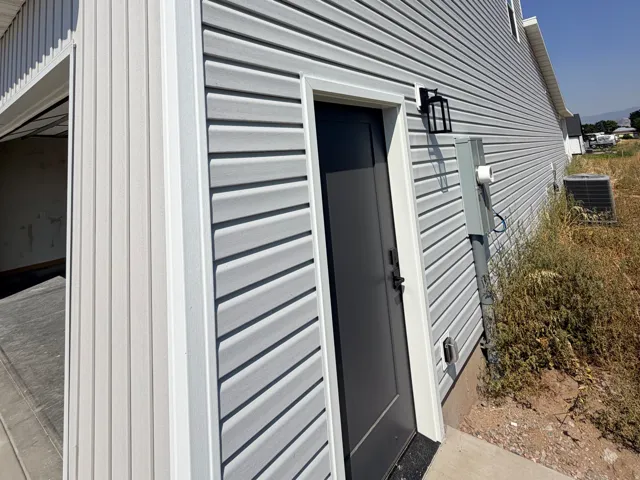 Exterior featuring light gray horizontal siding and vertical white accents