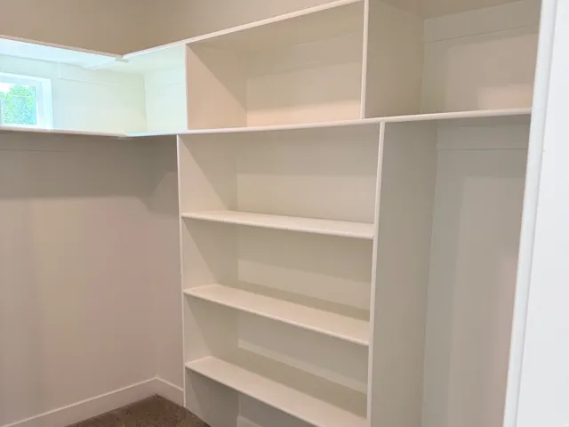 Built-in shelving system with multiple compartments and a window providing natural light