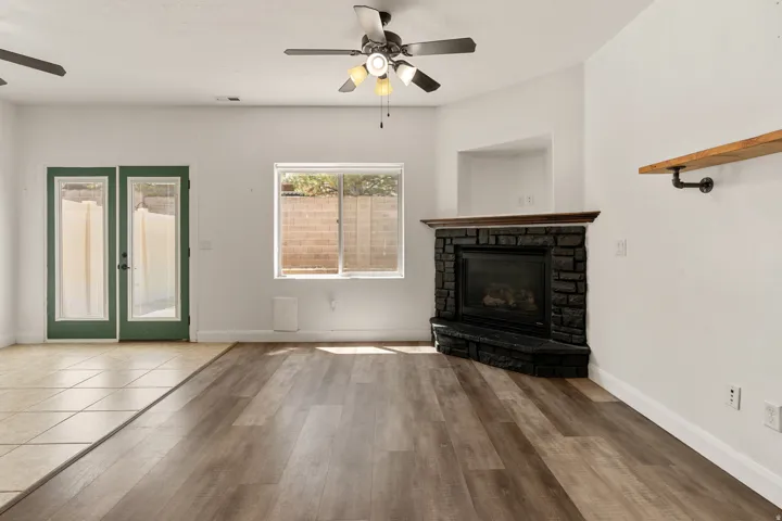 Interior space featuring wood-finish flooring and a corner-set fireplace with a stone surround