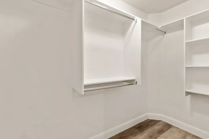 Custom closet system featuring white shelving and hanging rods