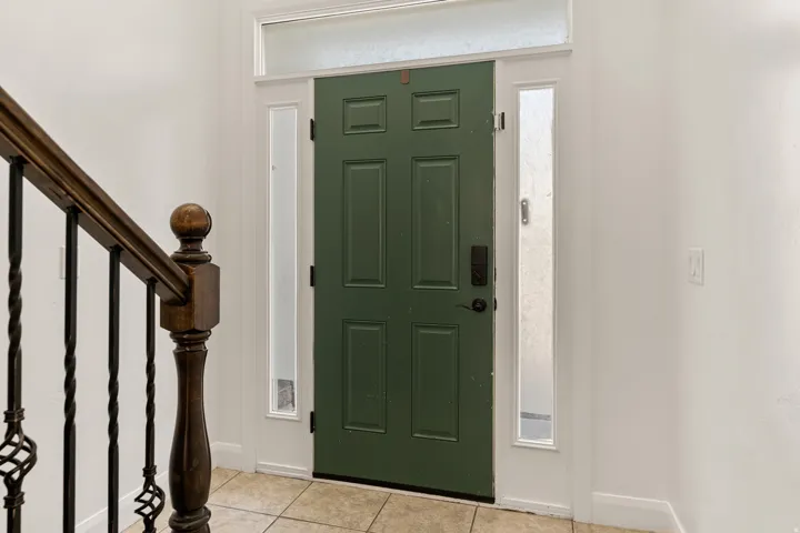 Panel-style entry door with frosted sidelights and transom window