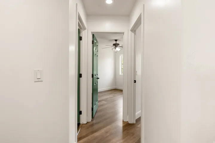 Hallway featuring light-colored walls and wood-finish flooring