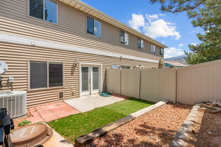Rear exterior featuring tan horizontal siding, white trim, and a two-story design