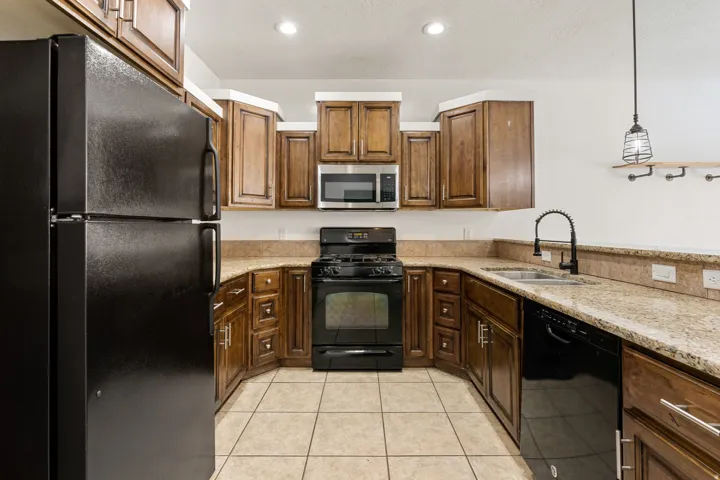 Kitchen featuring wood-finish cabinetry, light-toned countertops, and tile flooring