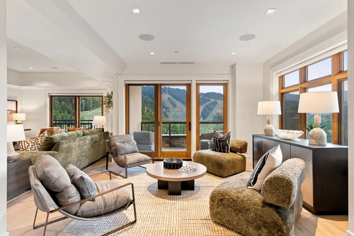 Bright living area with large windows, wood-finish flooring, recessed lighting, and a neutral color palette
