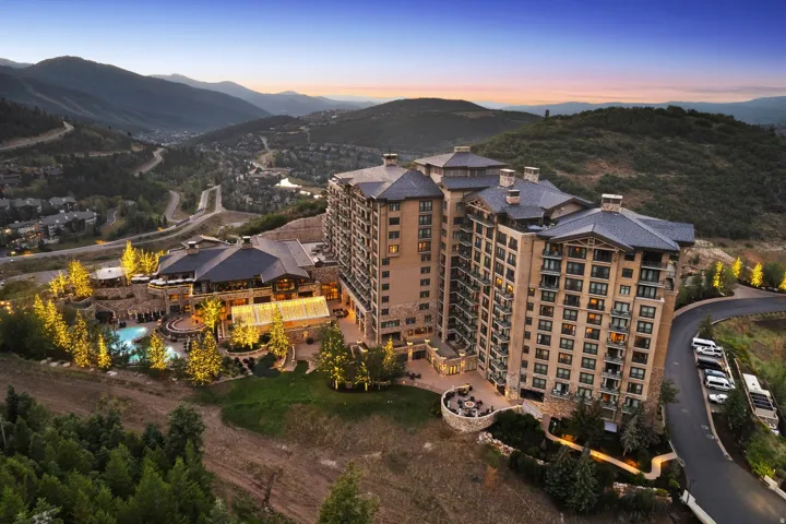 Expansive multi-story building featuring stacked balconies and a stone facade