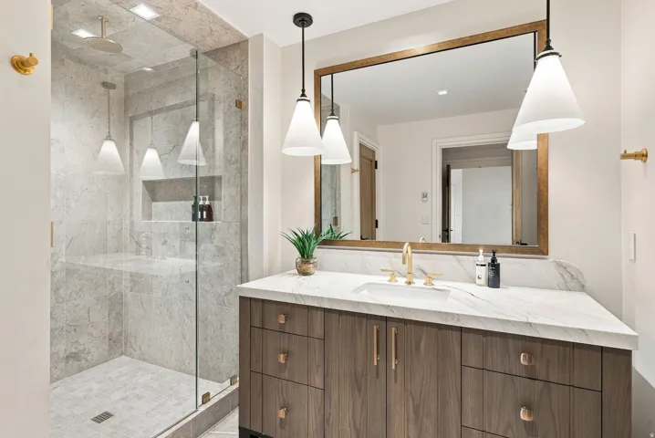 Modern bathroom featuring a wood-finish vanity with a white countertop and rectangular undermount sink