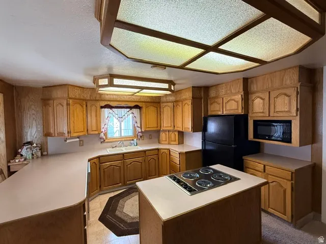 Spacious kitchen featuring wood cabinetry throughout, dual built-in wall ovens, gas cooktop with white countertop workspace, and a large island with seating