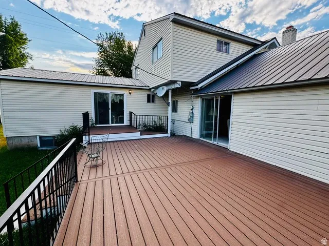 Expansive composite deck featuring black metal railings and direct access to the interior via two sliding glass doors