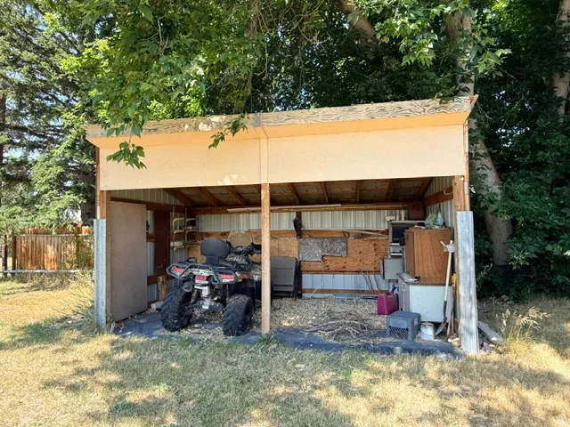 Open-sided shed with wood framing and corrugated metal siding