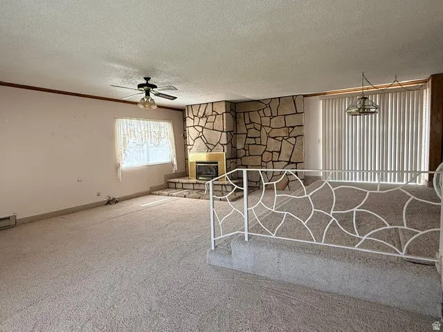 Living area featuring a stone-clad fireplace with a metal insert and hearth