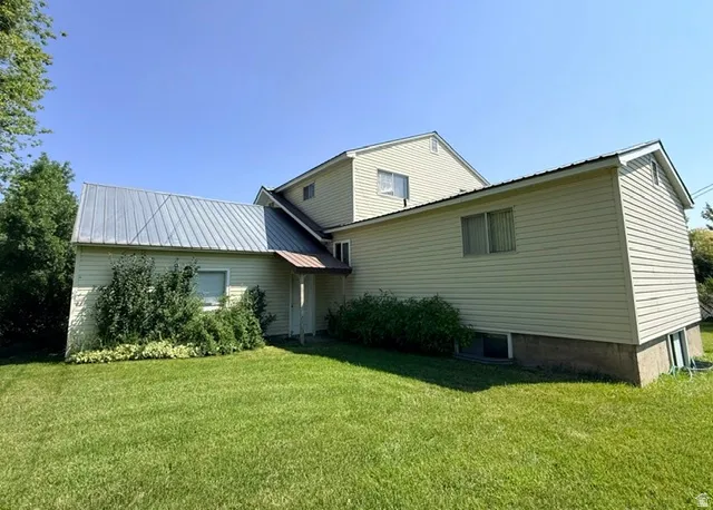 Charming farmhouse-style residence featuring vertical siding exterior, metal roof accents, and a gabled roofline