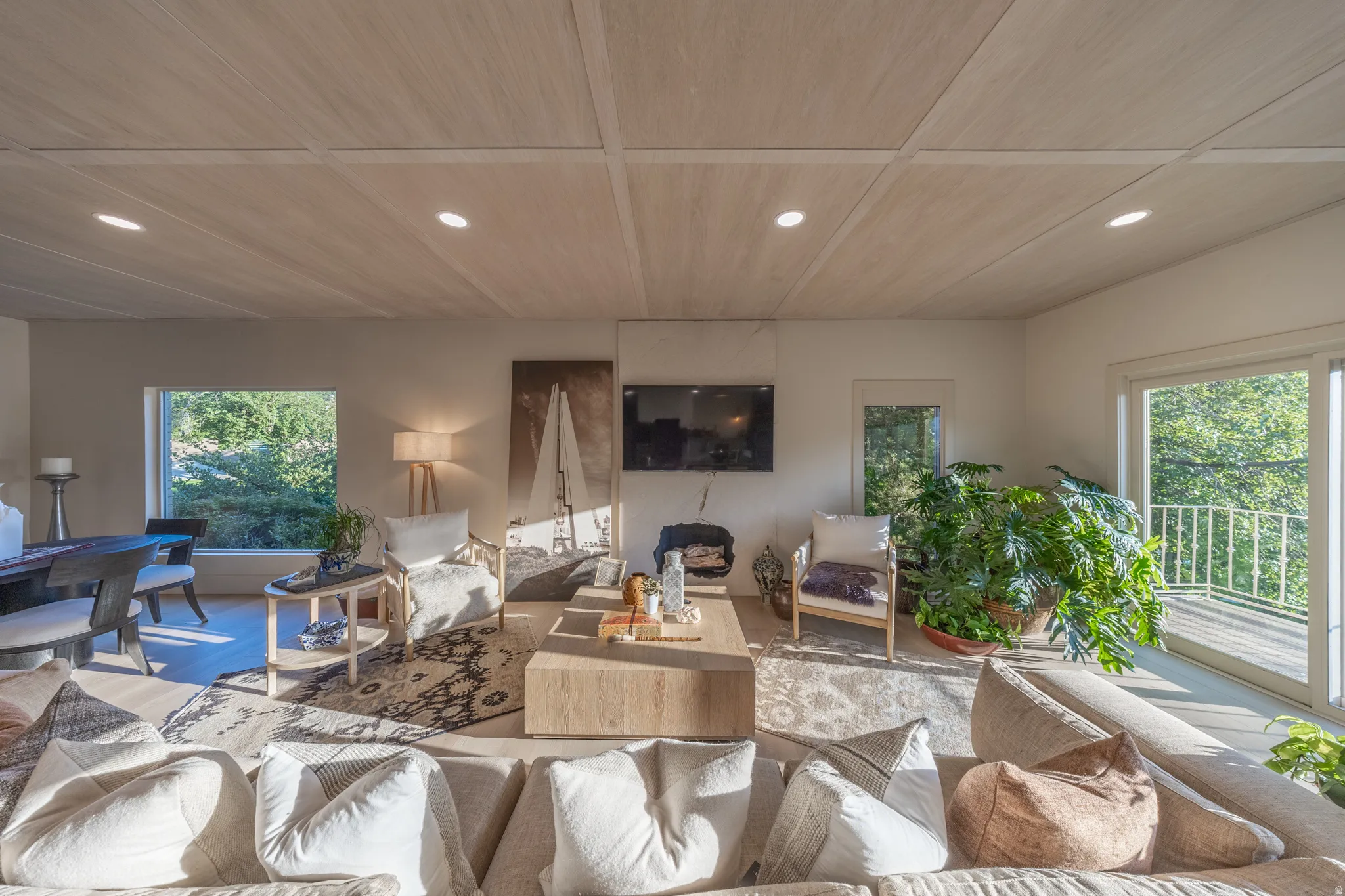 Bright, open-concept living space bathed in natural light from multiple glass sliding doors and transom windows