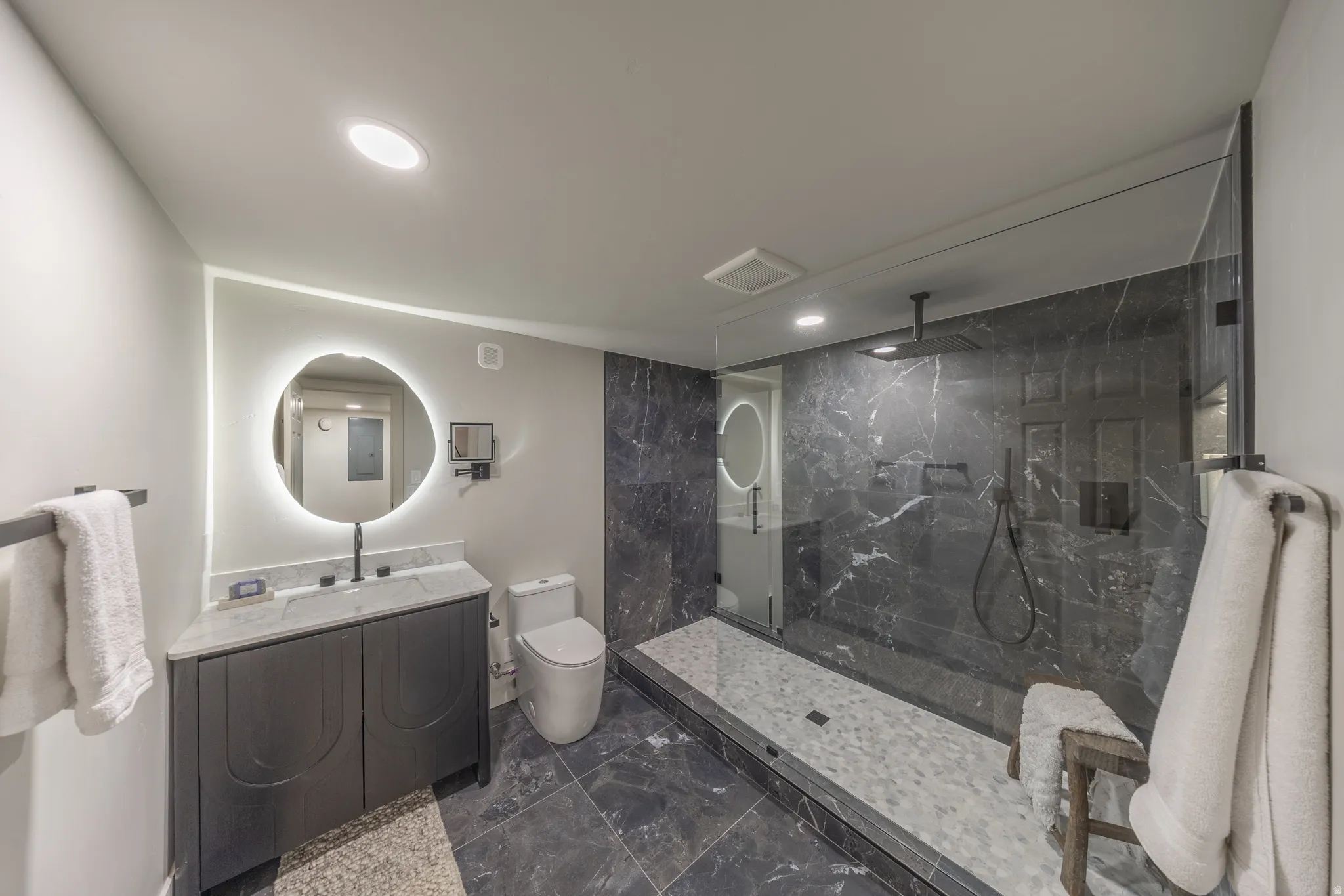 Contemporary bathroom featuring a spacious glass-enclosed shower with a rainfall showerhead and handheld sprayer