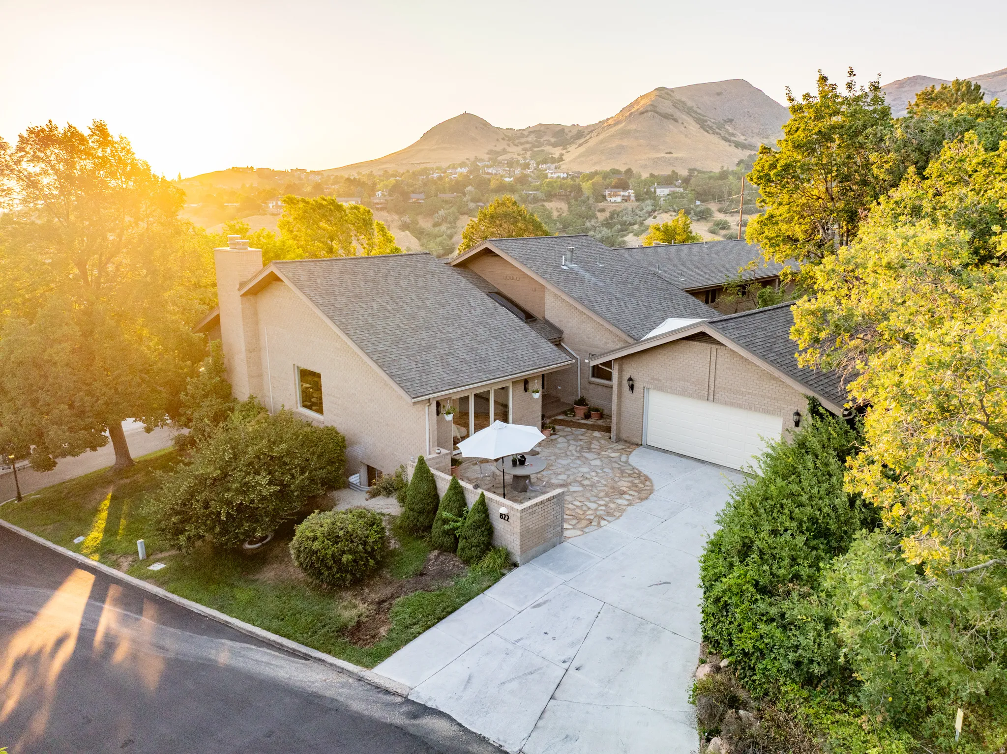 Modern single-story residence featuring a clean stucco exterior with a multi-pitched asphalt shingle roof