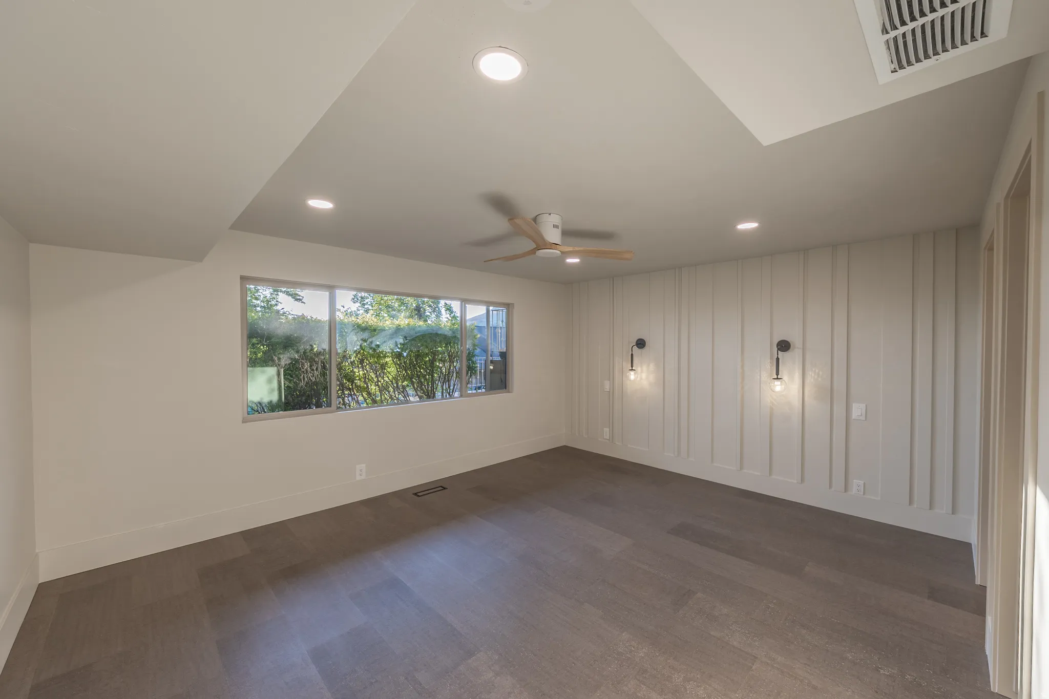 Spacious room with vaulted ceiling, recessed lighting, and ceiling fan