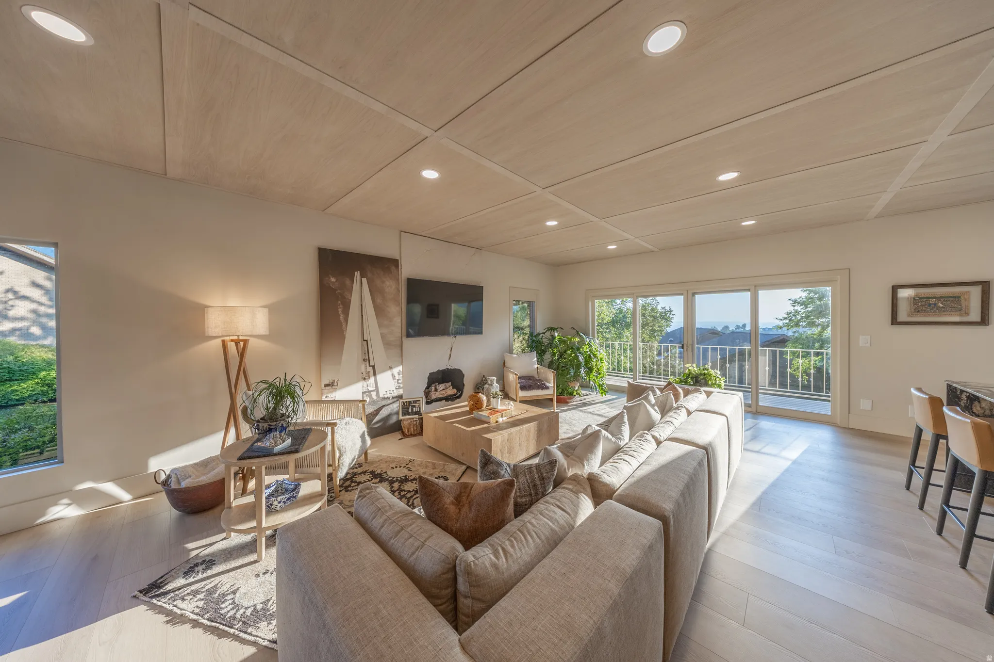 Bright, open-concept living area featuring expansive glass sliding doors and windows flooding the space with natural light