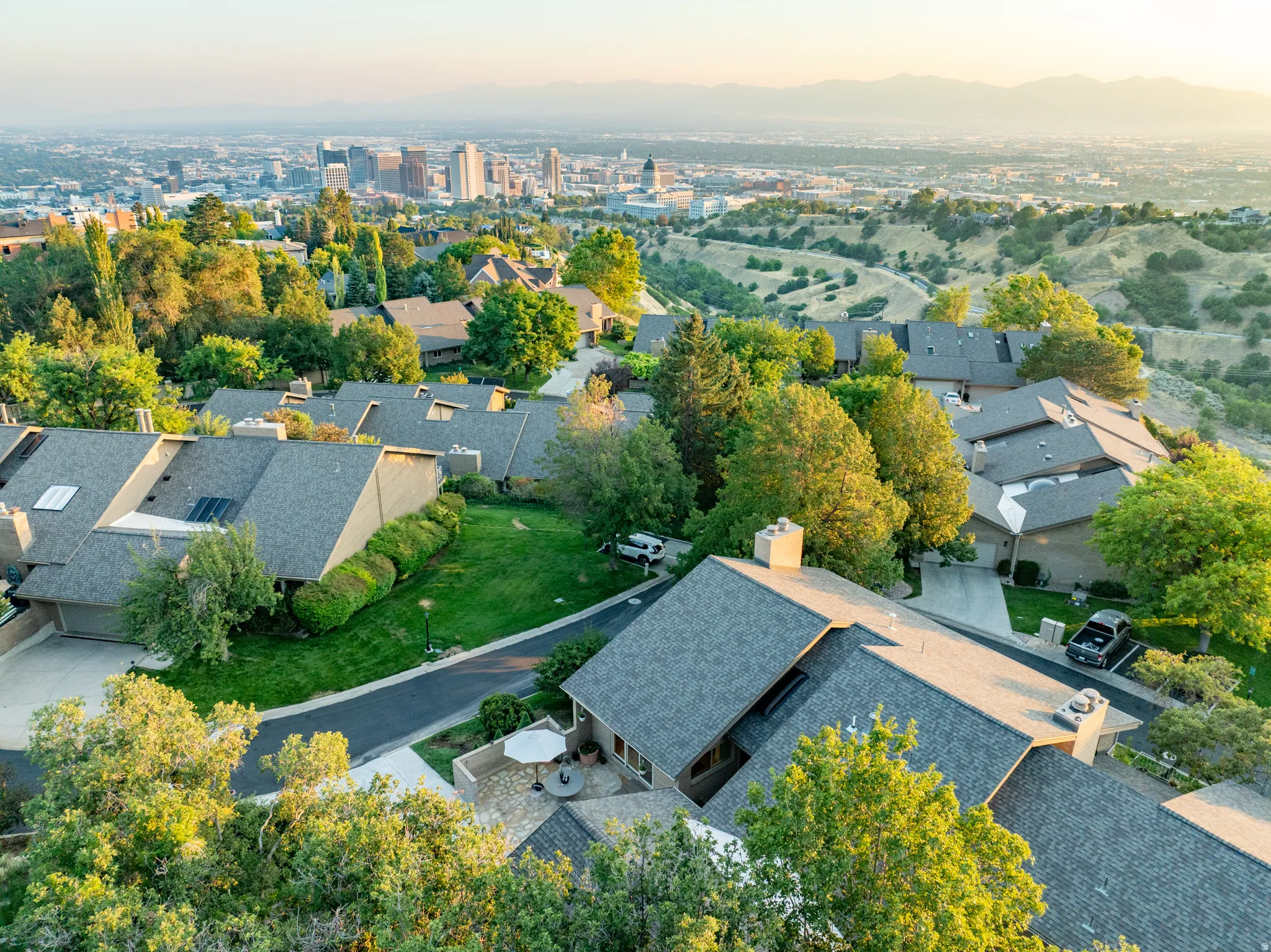 Prestigious hilltop estate showcasing multiple residences with slate-colored asphalt roofing, manicured lawns, and mature landscaping